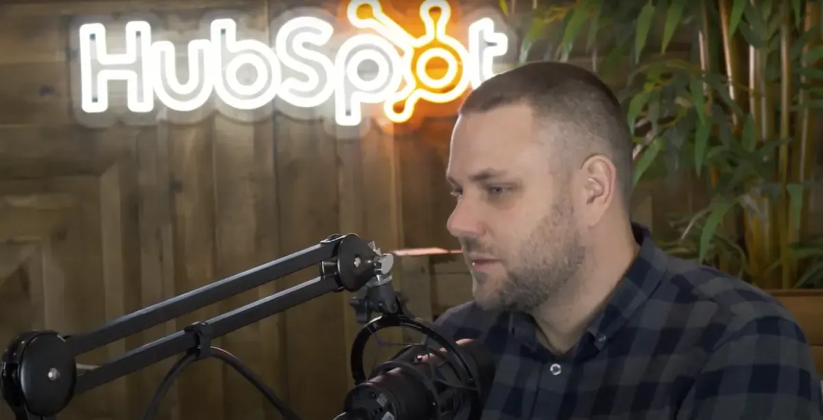 Rikki recording a podcast in front of a HubSpot sign