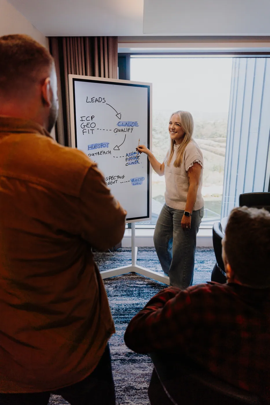 Emma presenting at the whiteboard to Rikki and Mark