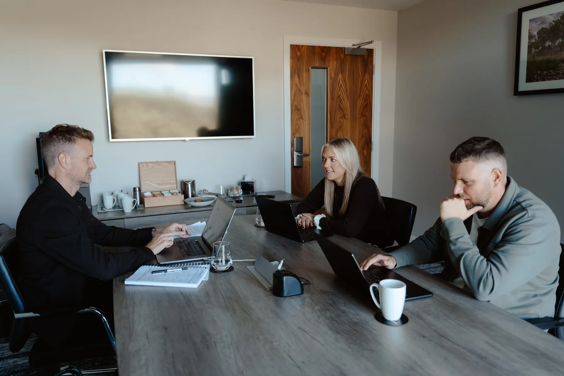 Mark, Emma and Rikki around the boardroom table