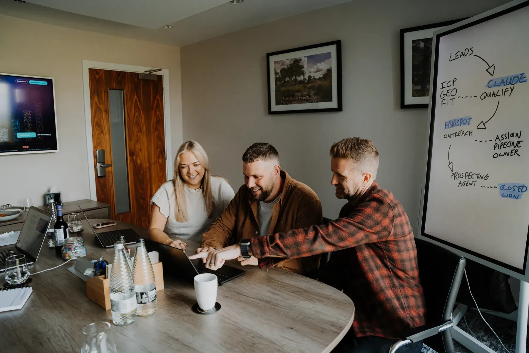Emma, Rikki and Mark working at a meeting-room table