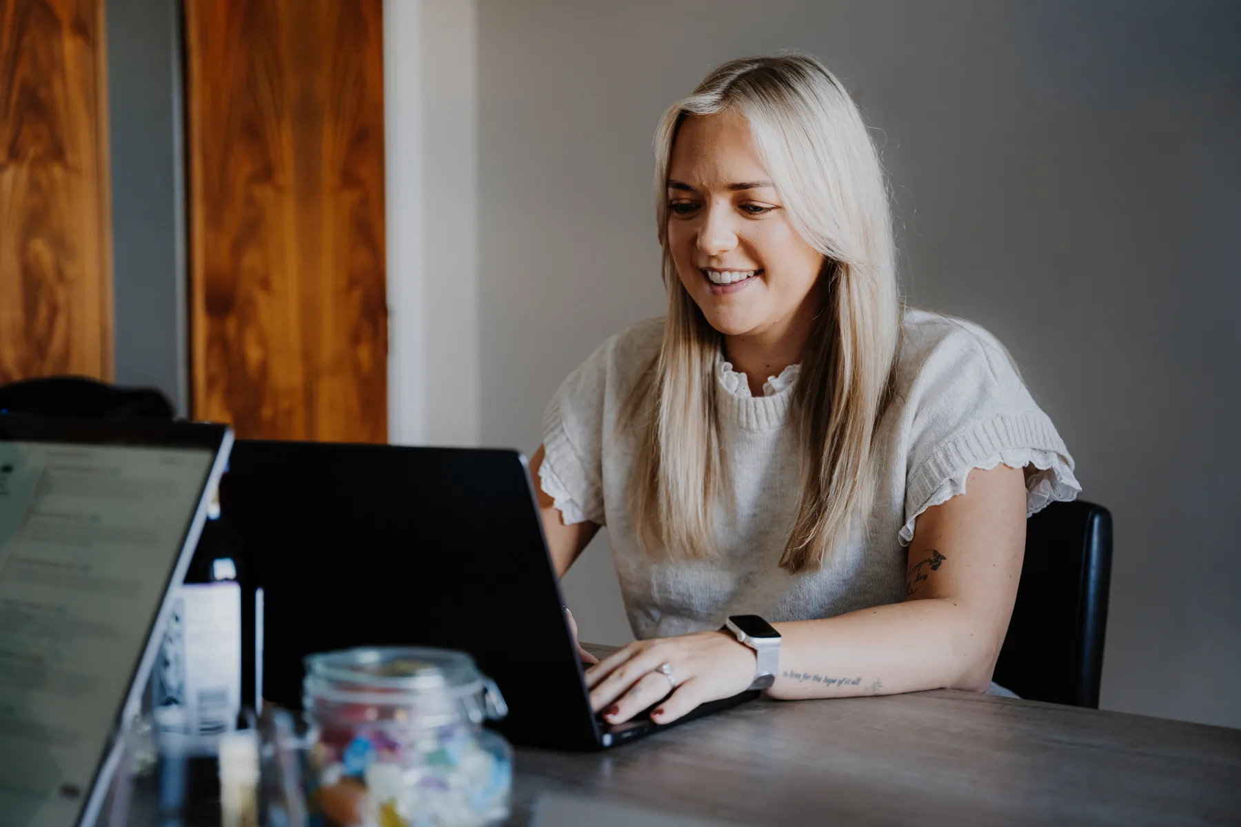 Emma smiling at her laptop in the meeting room
