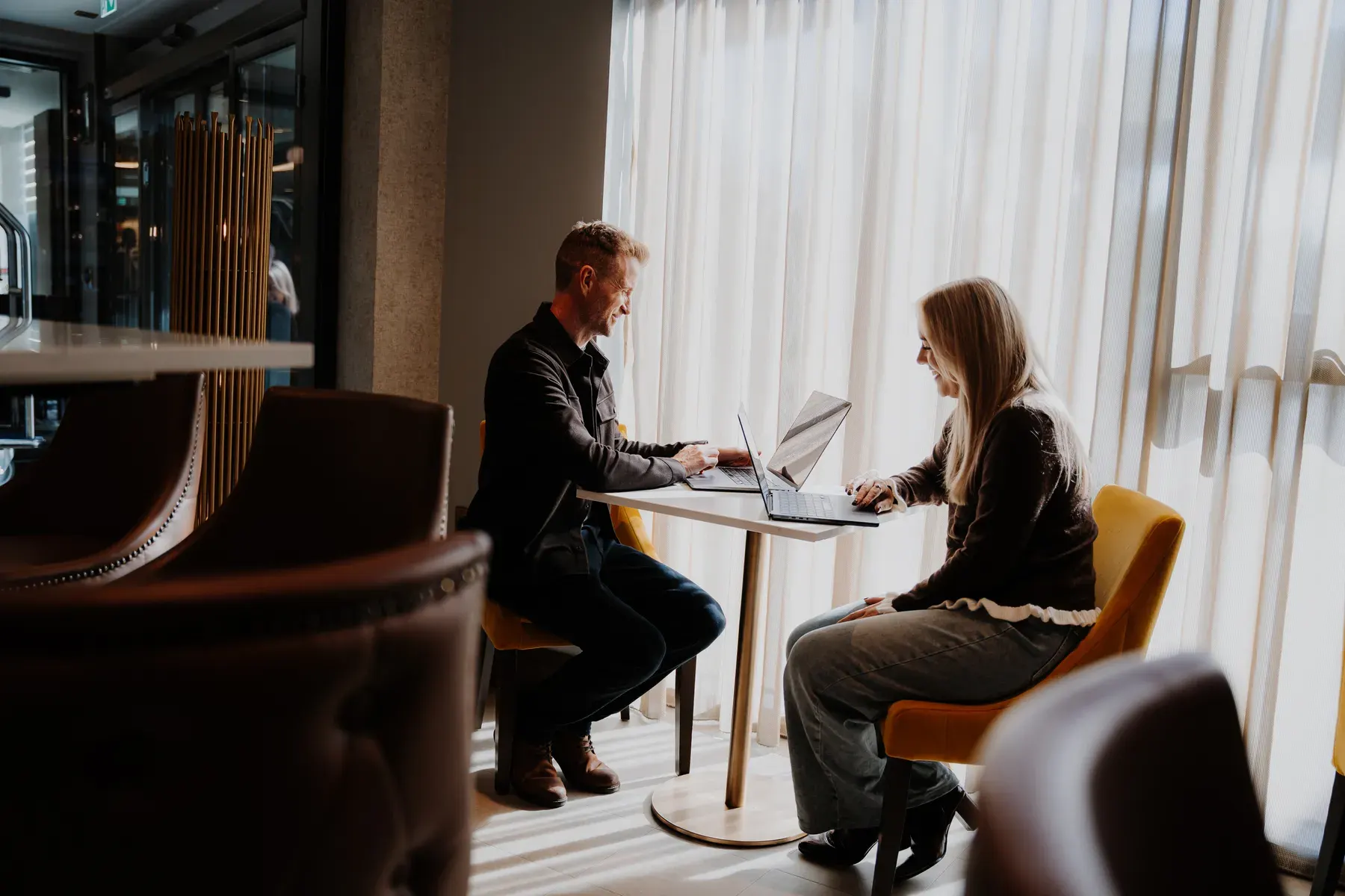 Mark and Emma at a table by the window