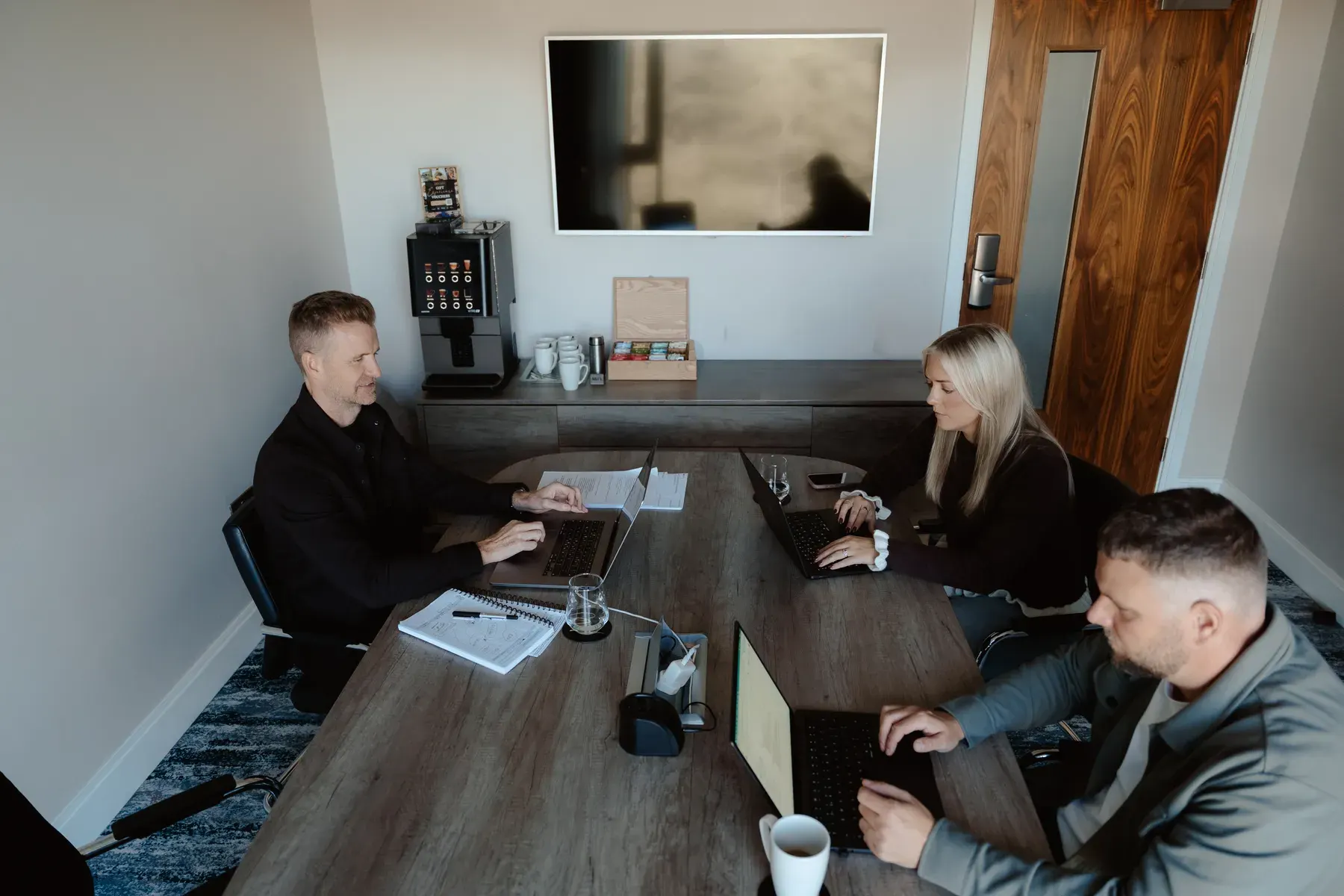 Mark, Emma and Rikki working around the boardroom table